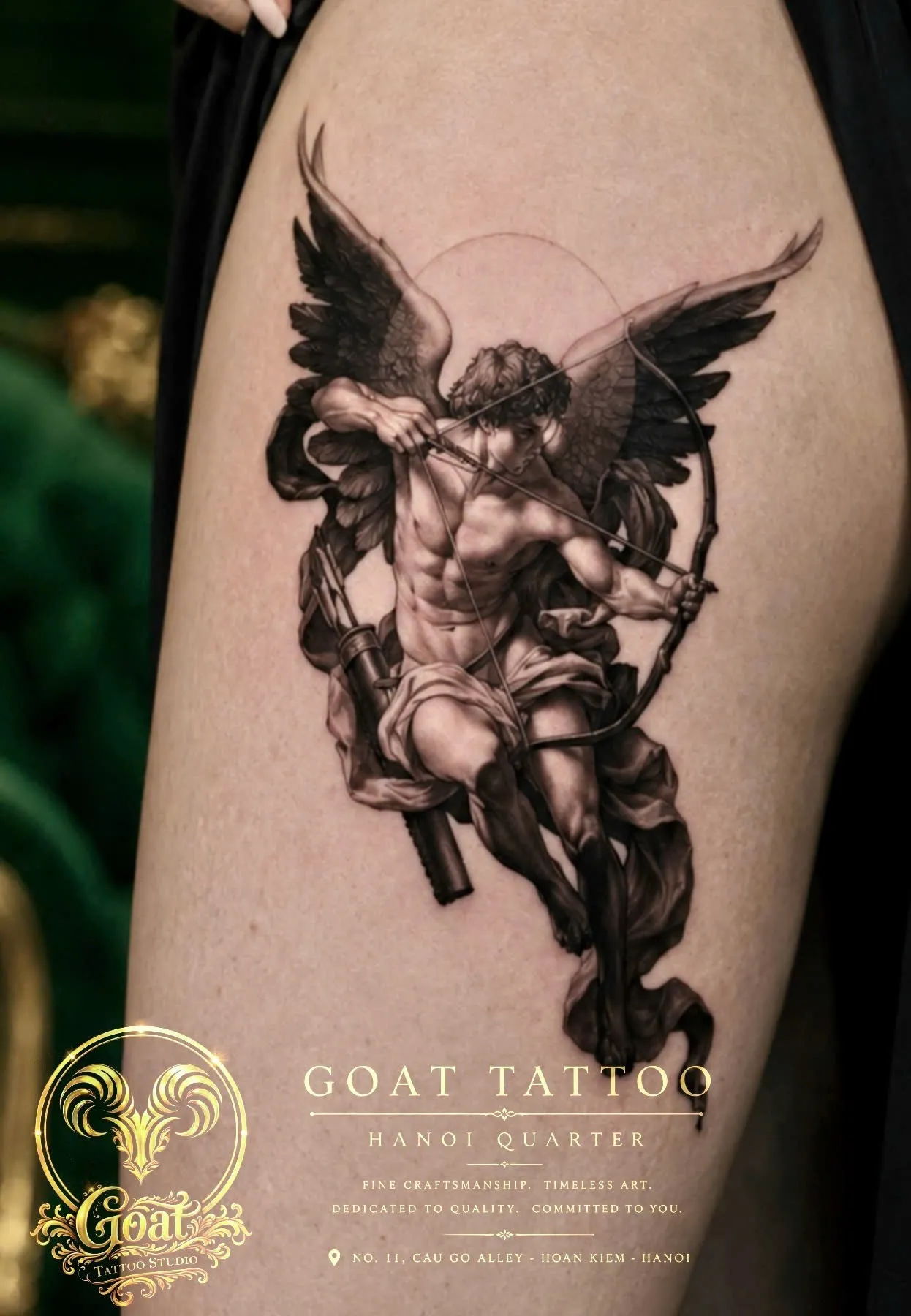 Black and grey realism angel archer tattoo covering the thigh, by GOAT Tattoo Studio in Hanoi.