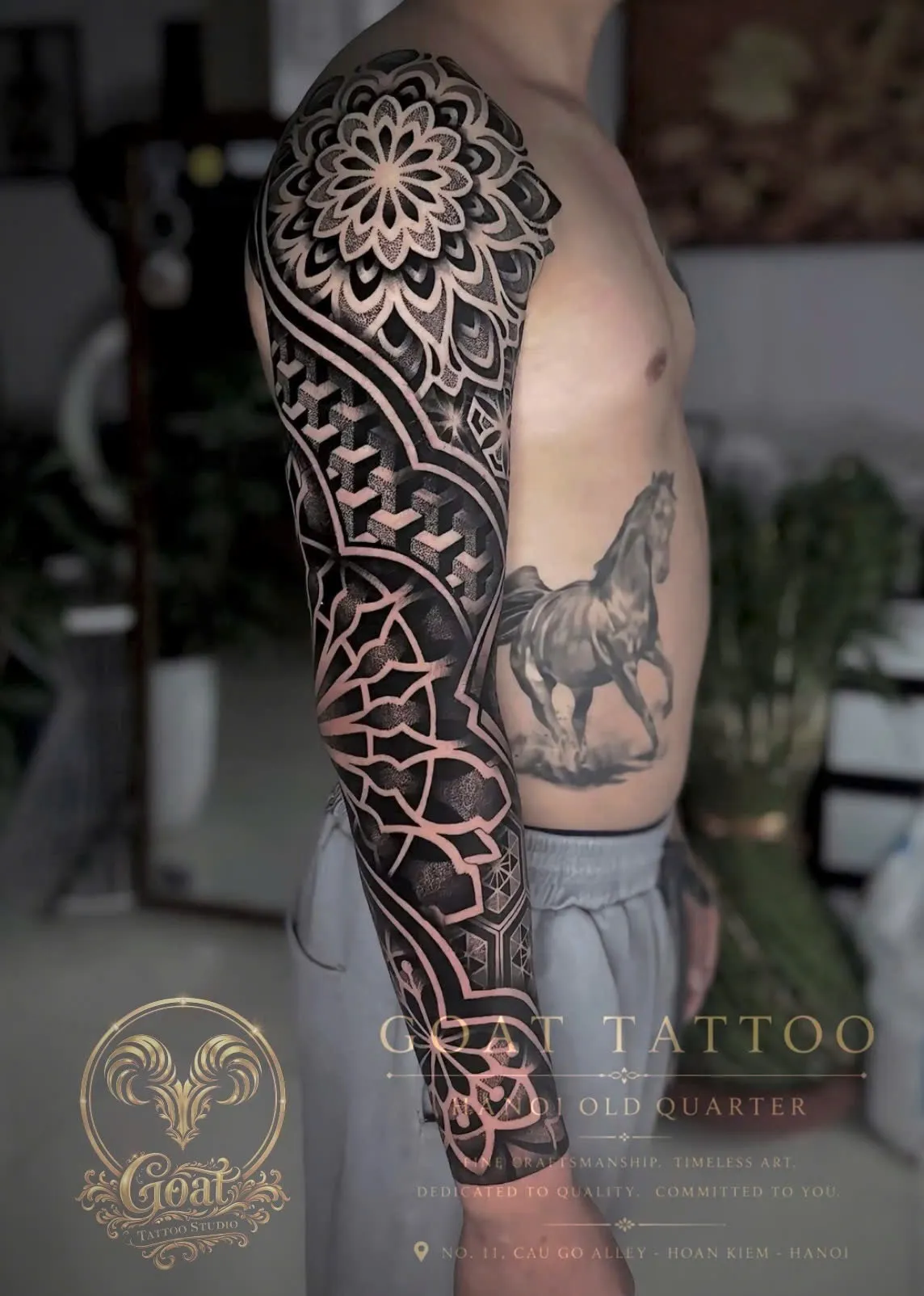 Blackwork dotwork mandala sleeve tattoo with intricate geometric patterns, by GOAT Tattoo Studio Hanoi.