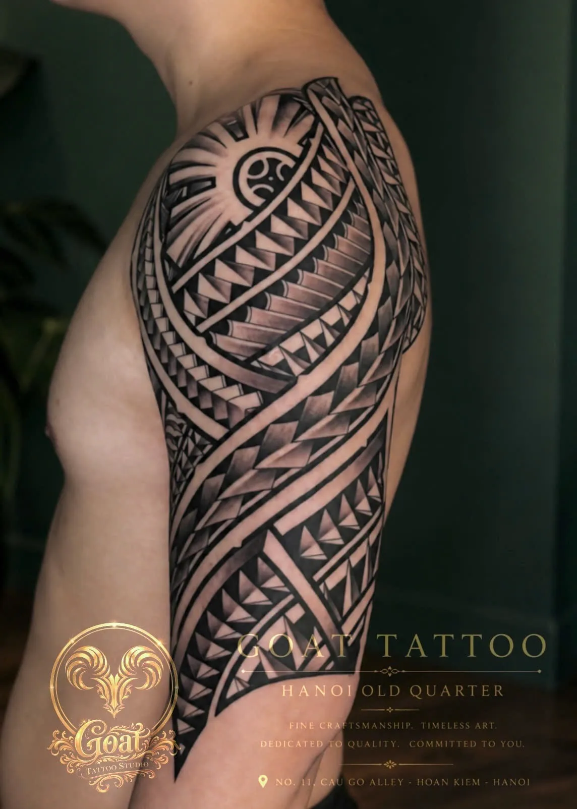 Blackwork Polynesian tribal tattoo with a sun motif covering the shoulder and upper arm, by GOAT Tattoo Studio in Hanoi.