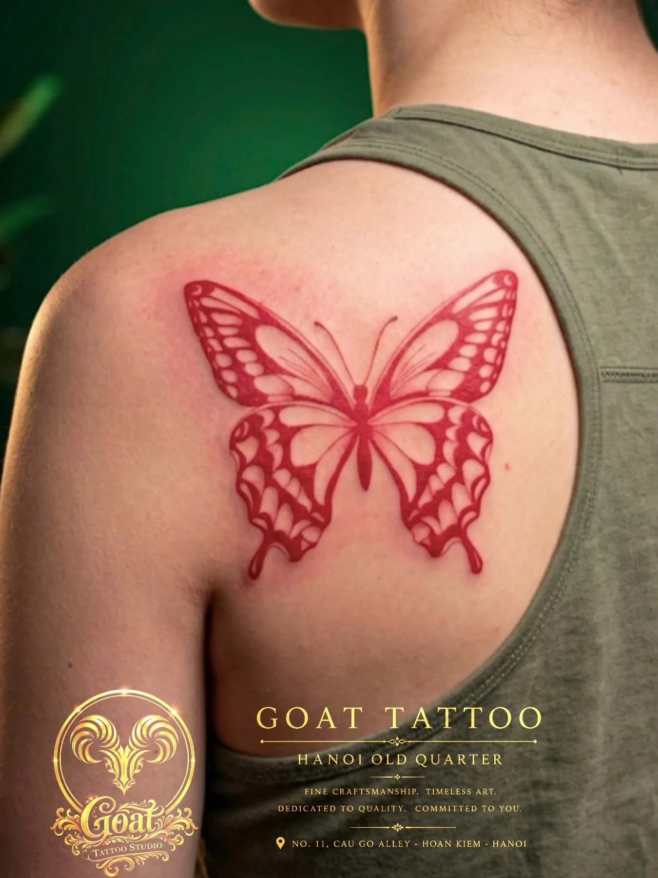 Bold red blackwork-style butterfly tattoo with patterned wings on the shoulder blade, by GOAT Tattoo Studio in Hanoi.