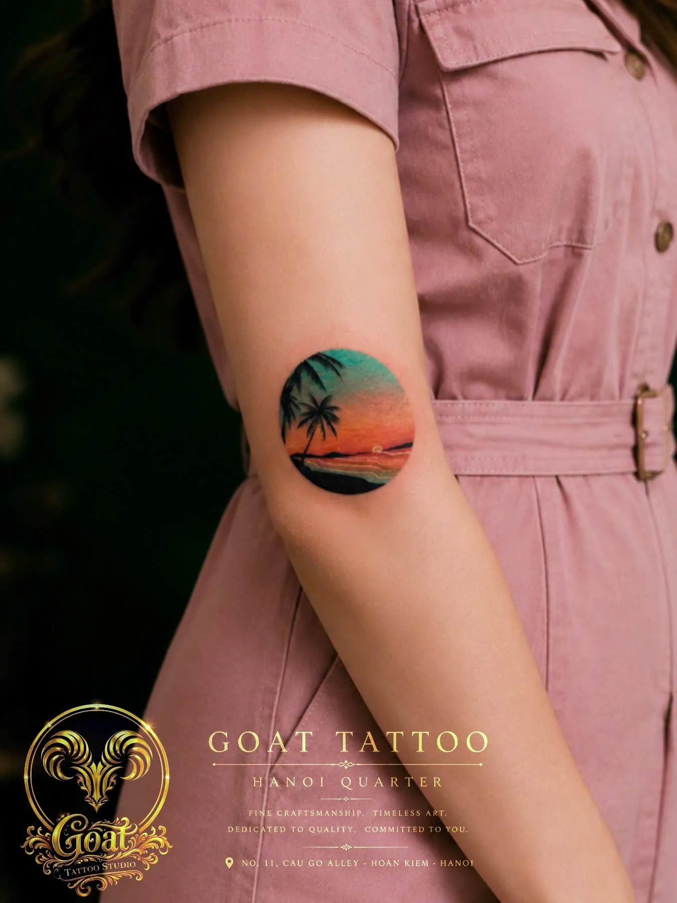 Color watercolor sunset palm tree scene framed in a circle on the upper arm, by GOAT Tattoo Studio, Hanoi.