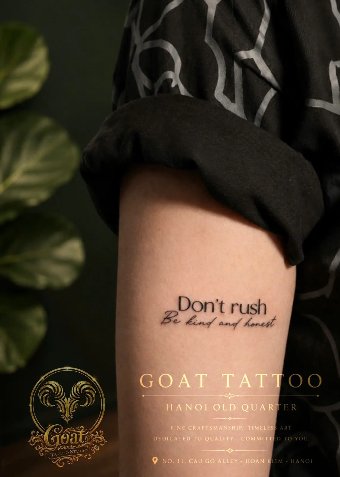 A delicate black script tattoo reading "Don't rush, be kind and honest" along the upper arm, done at GOAT Tattoo Studio in Hanoi's Old Quarter.