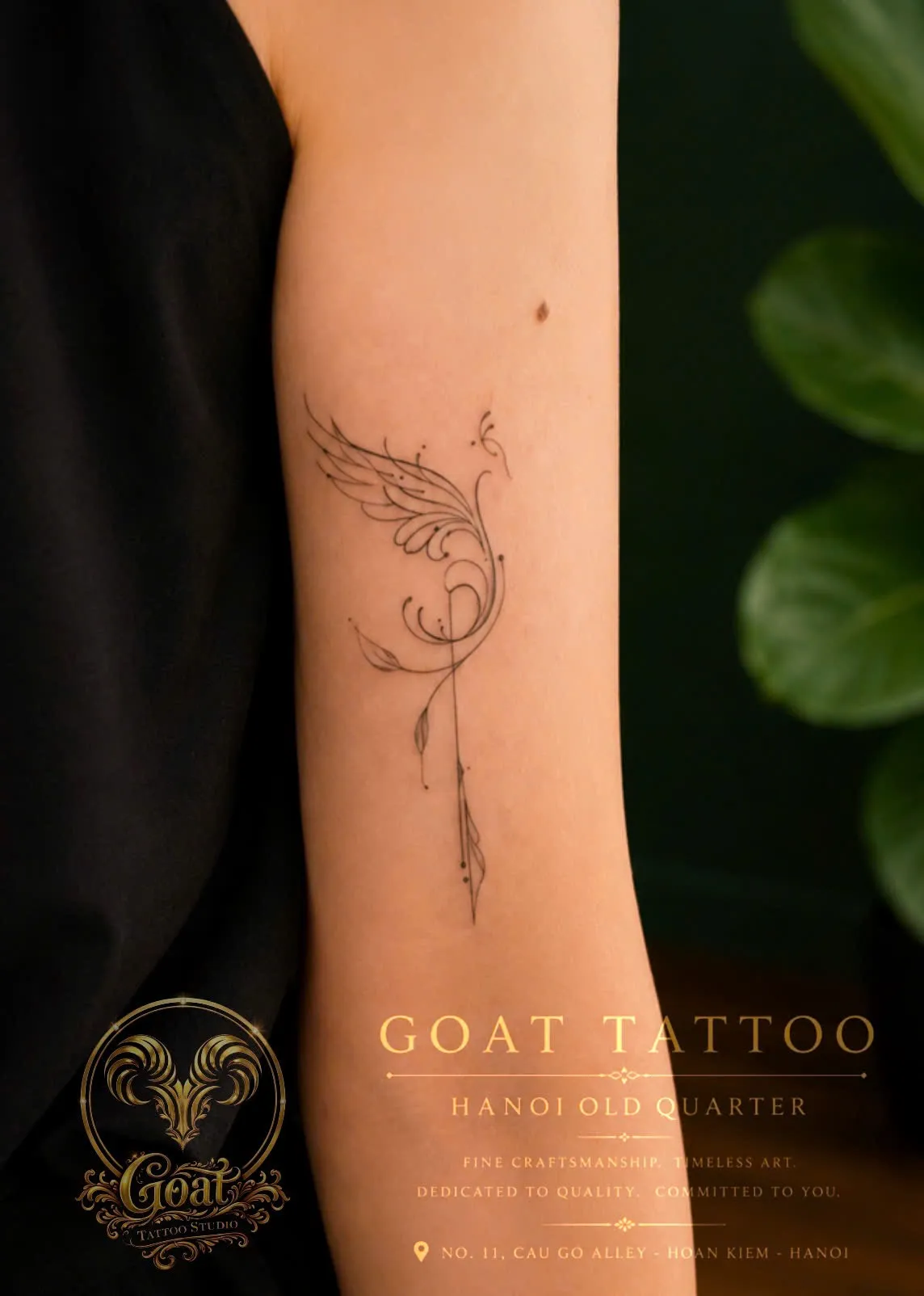 An elegant fine-line tattoo of a stylized bird taking flight above a feathered arrow on the forearm, done at GOAT Tattoo Studio in Hanoi's Old Quarter.