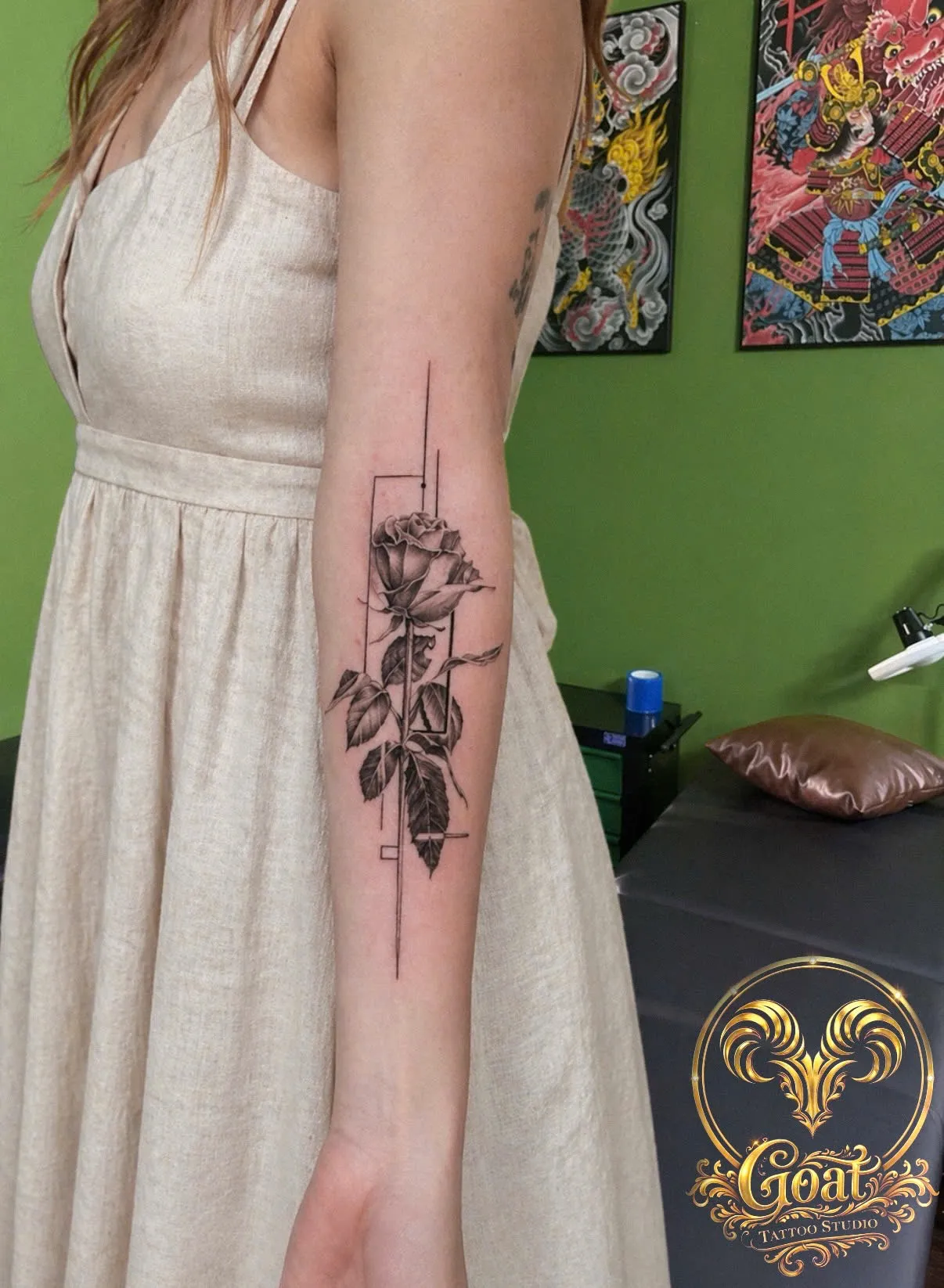 Fine line rose framed by minimalist geometric lines on the forearm, by GOAT Tattoo Studio in Hanoi's Old Quarter.