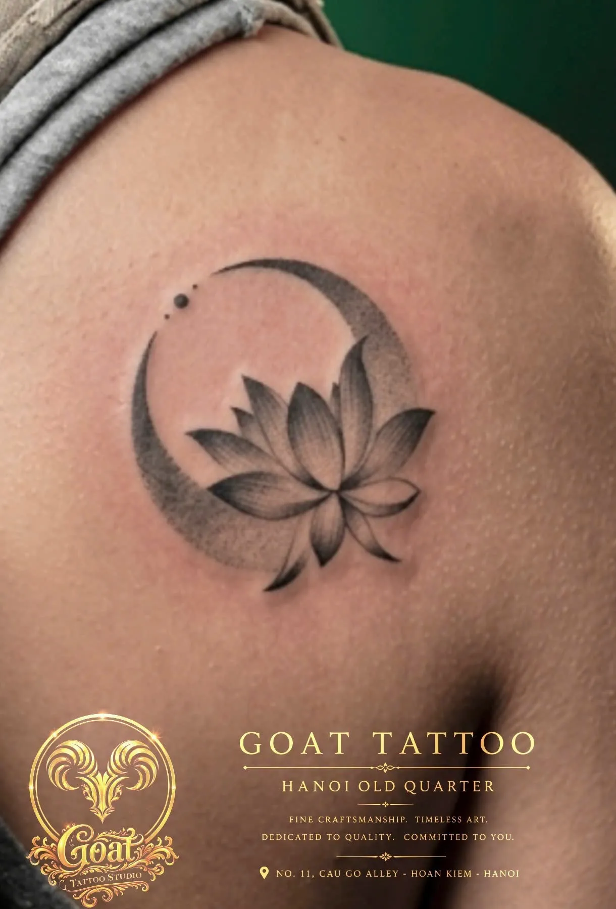 Fine line crescent moon wrapped around a blooming lotus flower on the shoulder blade, GOAT Tattoo Studio Hanoi.