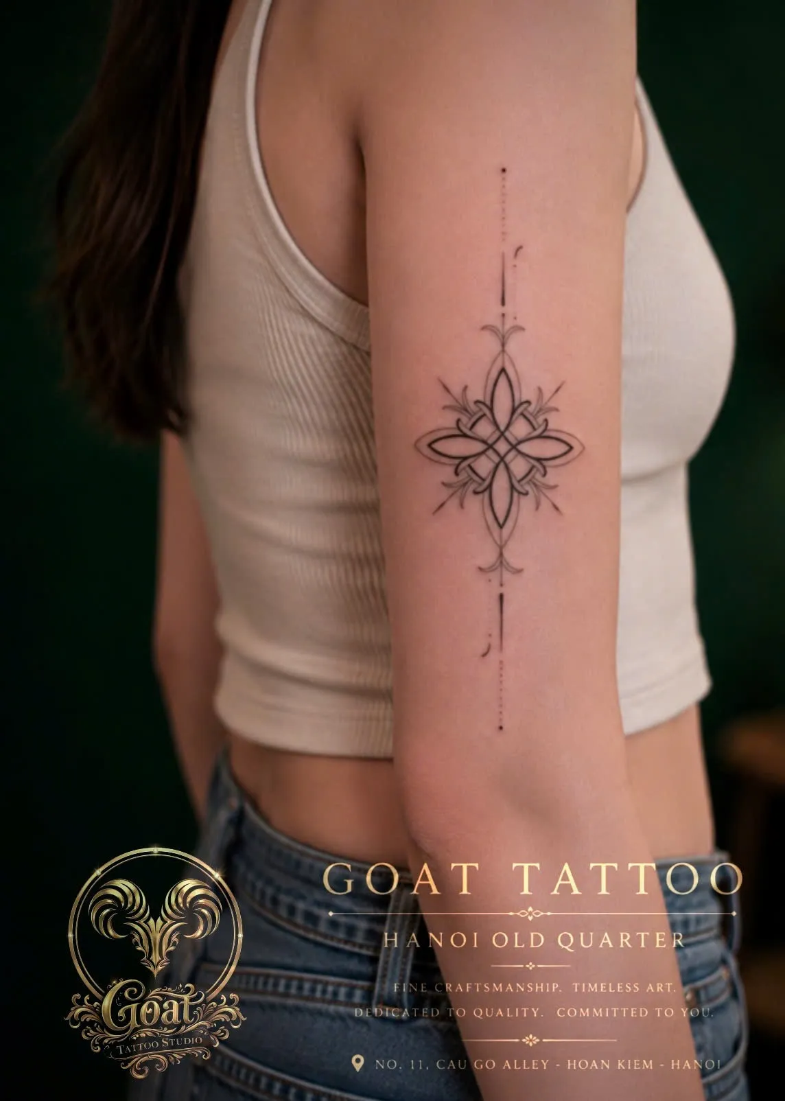 Symmetrical fine line ornamental mandala tattoo running down the upper arm, GOAT Tattoo Studio Hanoi.
