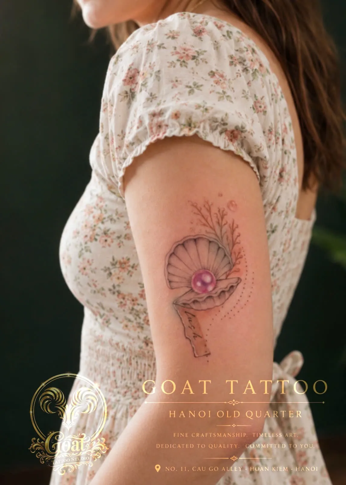 Fine line seashell and pearl tattoo with small script lettering, on the upper arm, by GOAT Tattoo Studio in Hanoi.