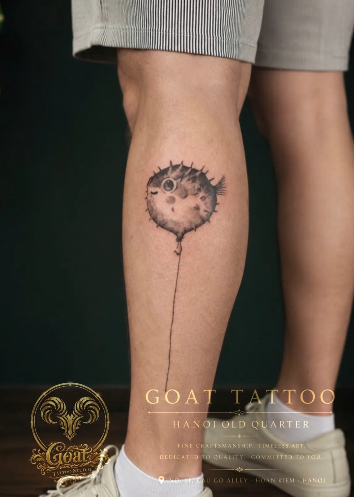 Fine line illustrative tattoo of a pufferfish shaped like a balloon, on the calf, by GOAT Tattoo Studio Hanoi.