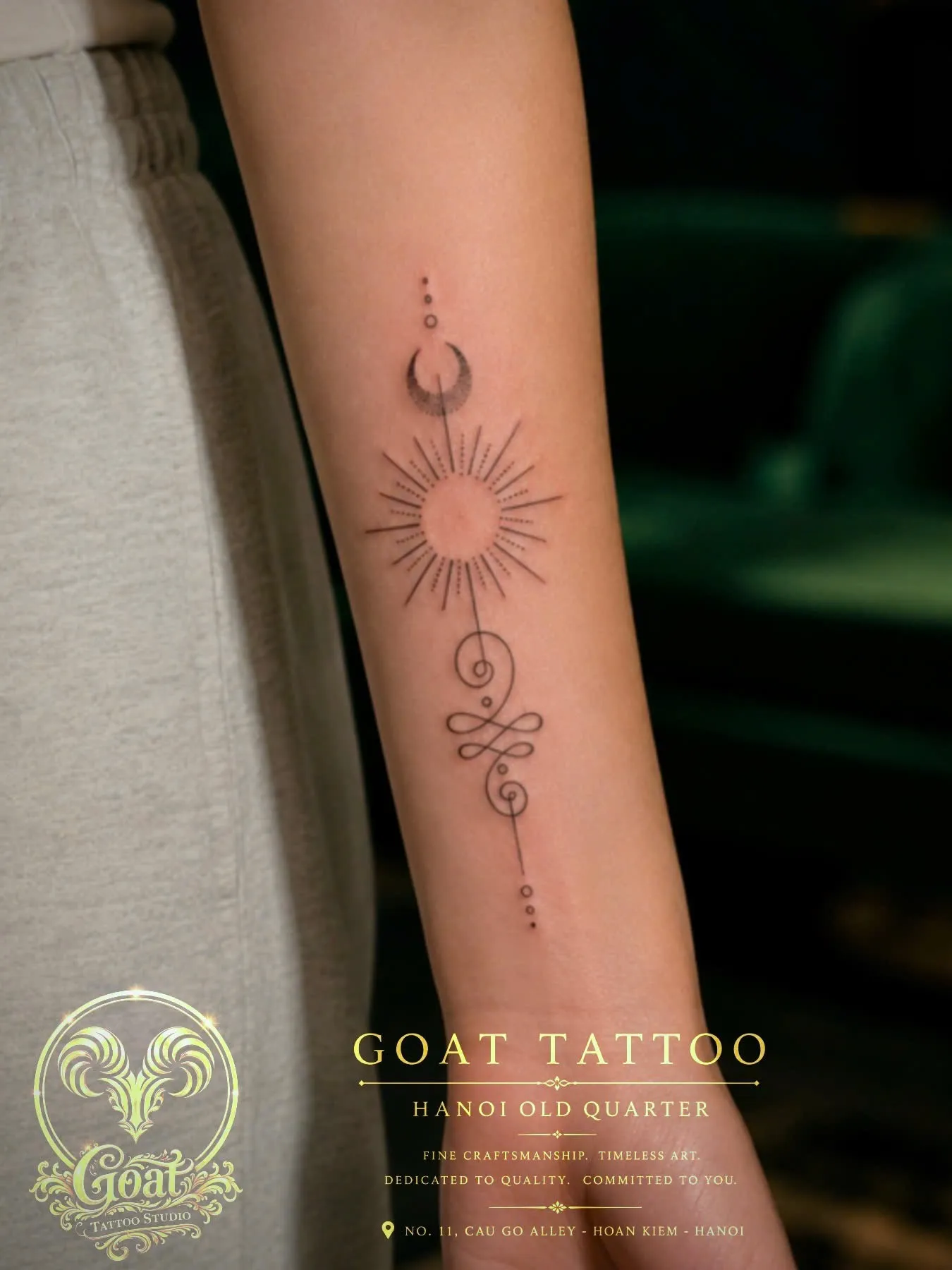Fine line sun and moon celestial tattoo running down the inner forearm, by GOAT Tattoo Studio in Hanoi.