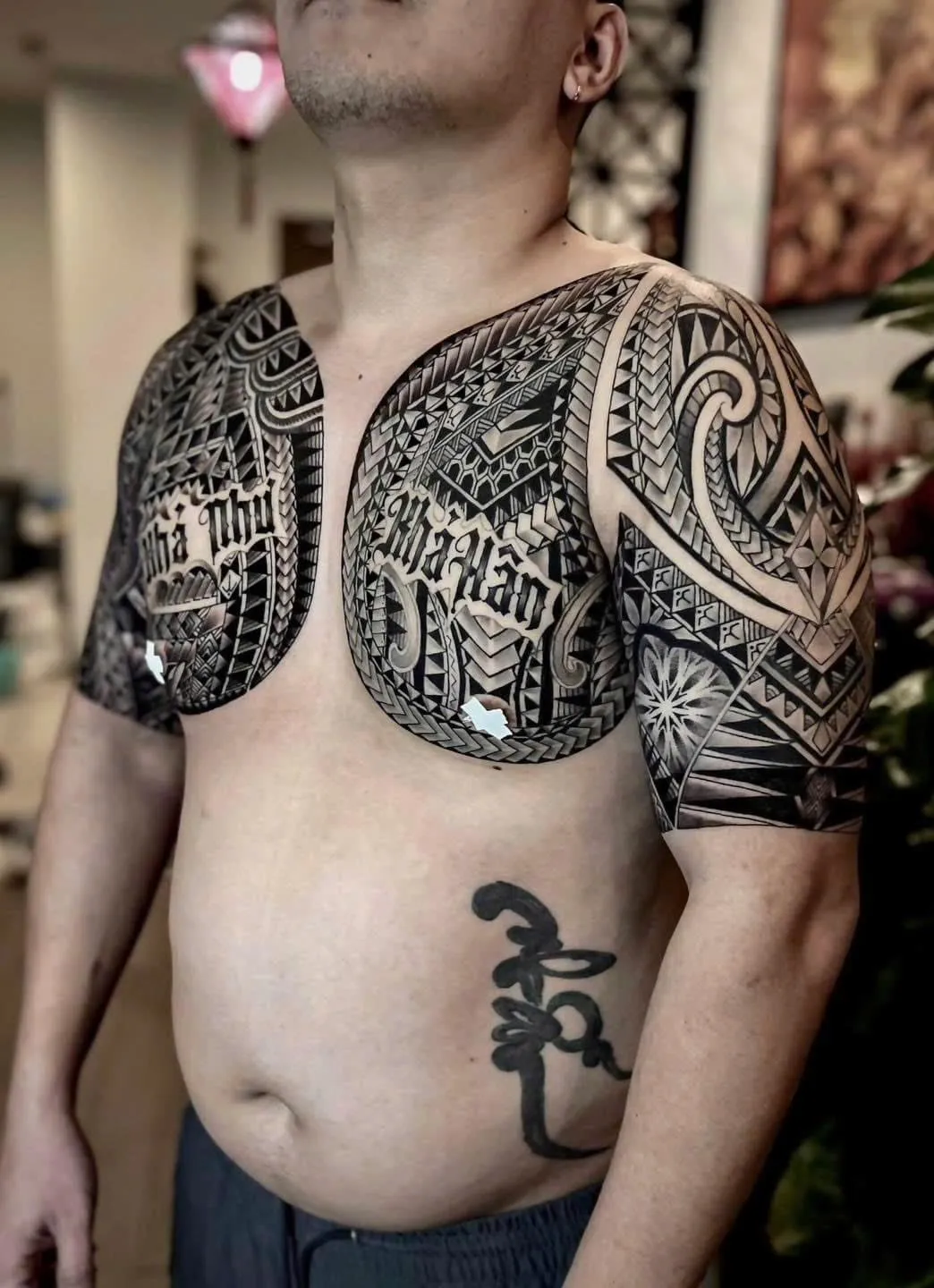 Bold Maori and Polynesian blackwork across the chest, both shoulders and upper arms, done at GOAT Tattoo Studio in Hanoi.