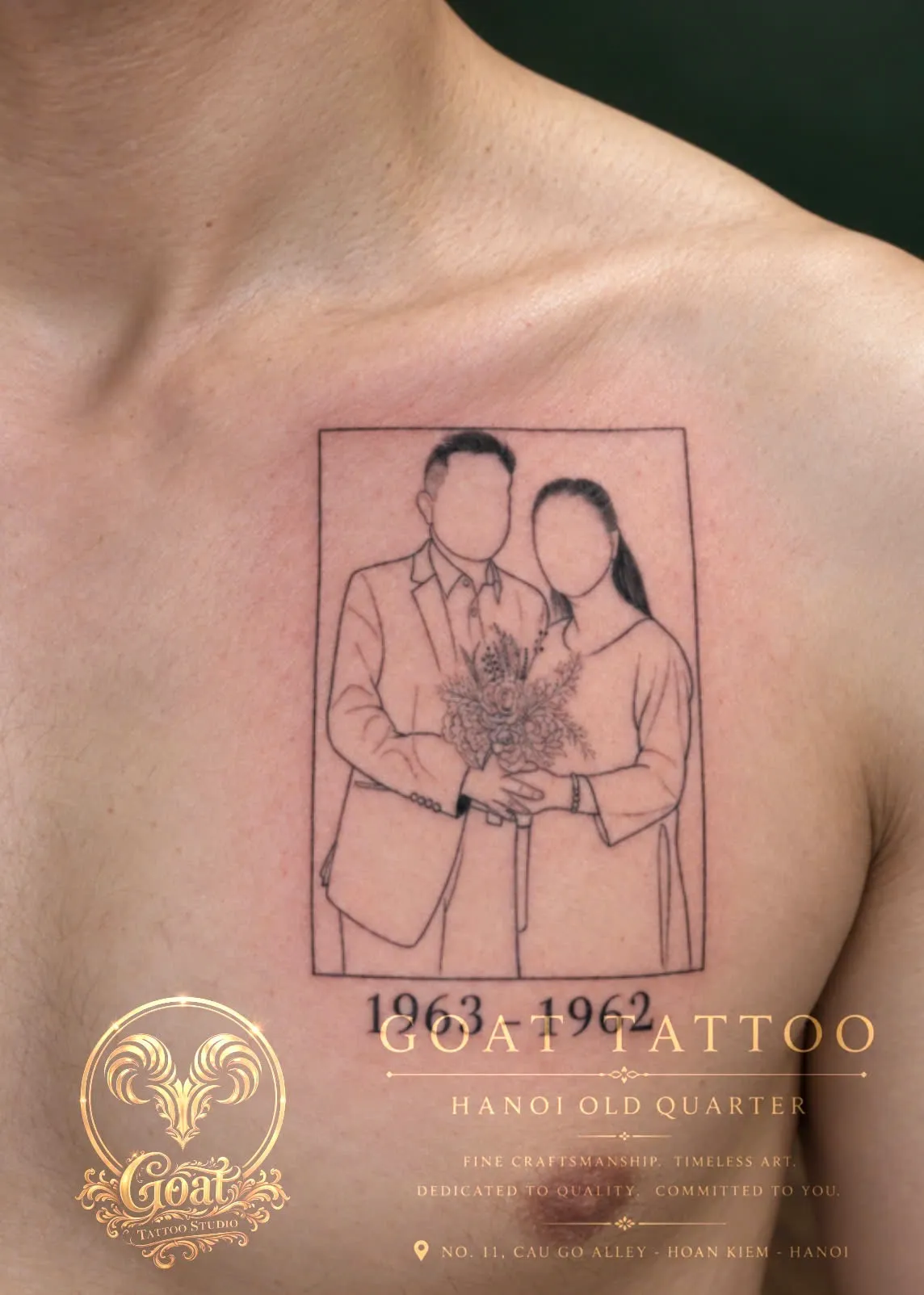 A fine line memorial portrait of a couple in a photo frame with their birth years, tattooed on the chest, by GOAT Tattoo Studio Hanoi.