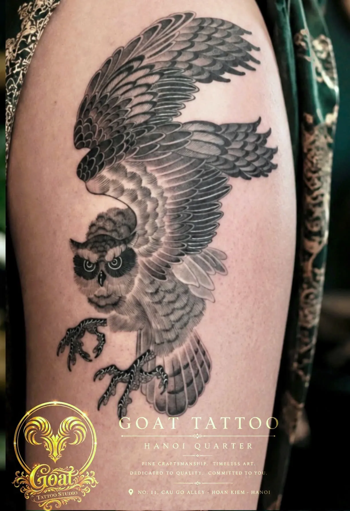 Black and grey realistic owl tattoo with detailed feathers on the thigh, by GOAT Tattoo Studio, Hanoi.