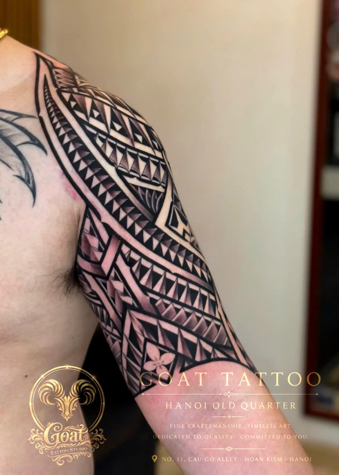 A black and grey skull wrapped in rope beneath a dripping candle, tattooed on the forearm, by GOAT Tattoo Studio in Hanoi's Old Quarter.
