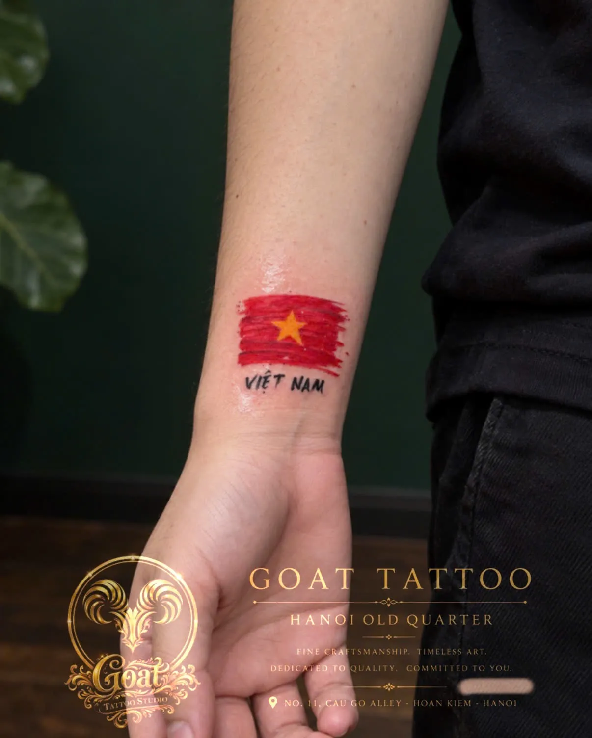 A brush-stroke style Vietnam flag with the word Vietnam, tattooed on the wrist, by GOAT Tattoo Studio Hanoi.